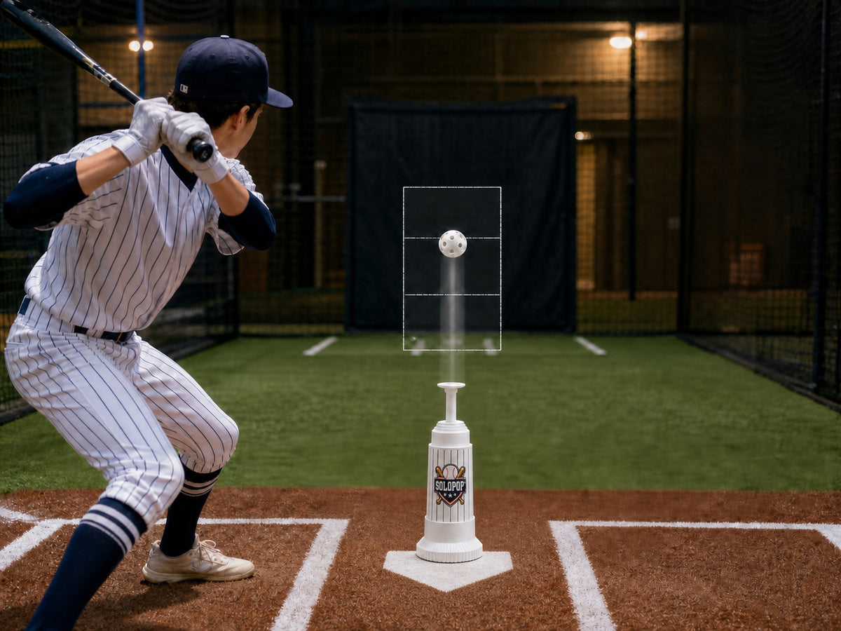 Baseball hitter watching a lightweight perforated training ball rise from the exact SOLOPOP Batting Trainer